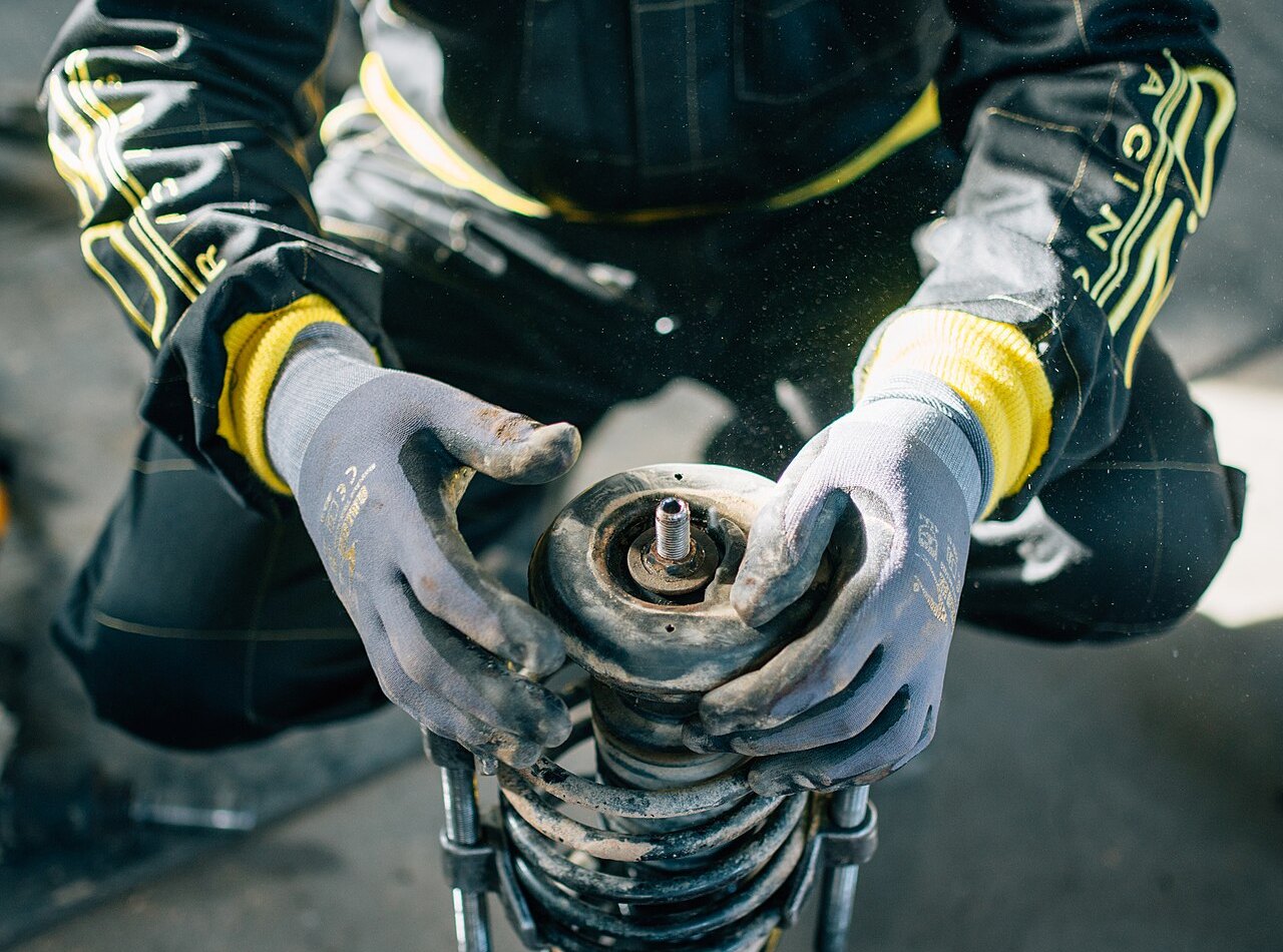 Mechanic holding a worn shock absorber